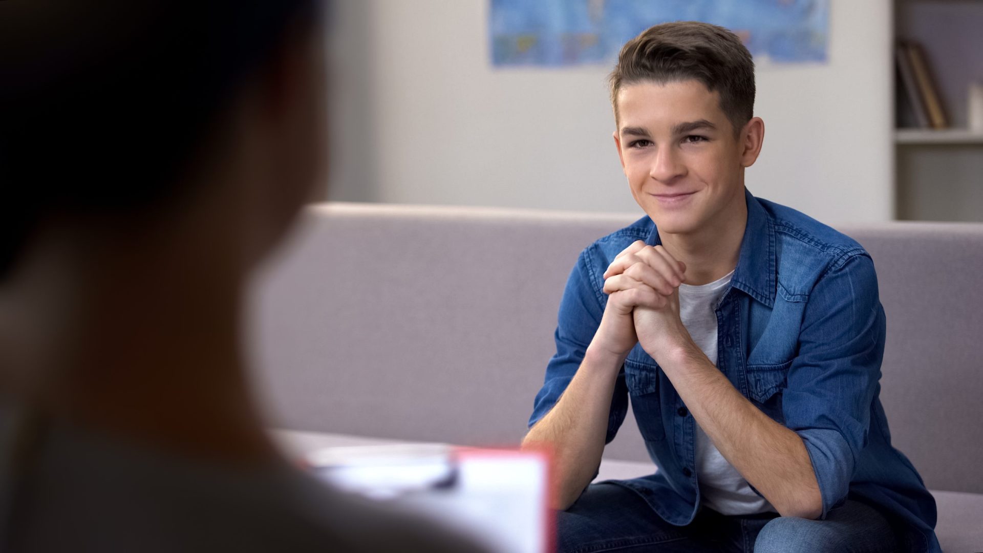 Teenager smiling and talking with a therapist