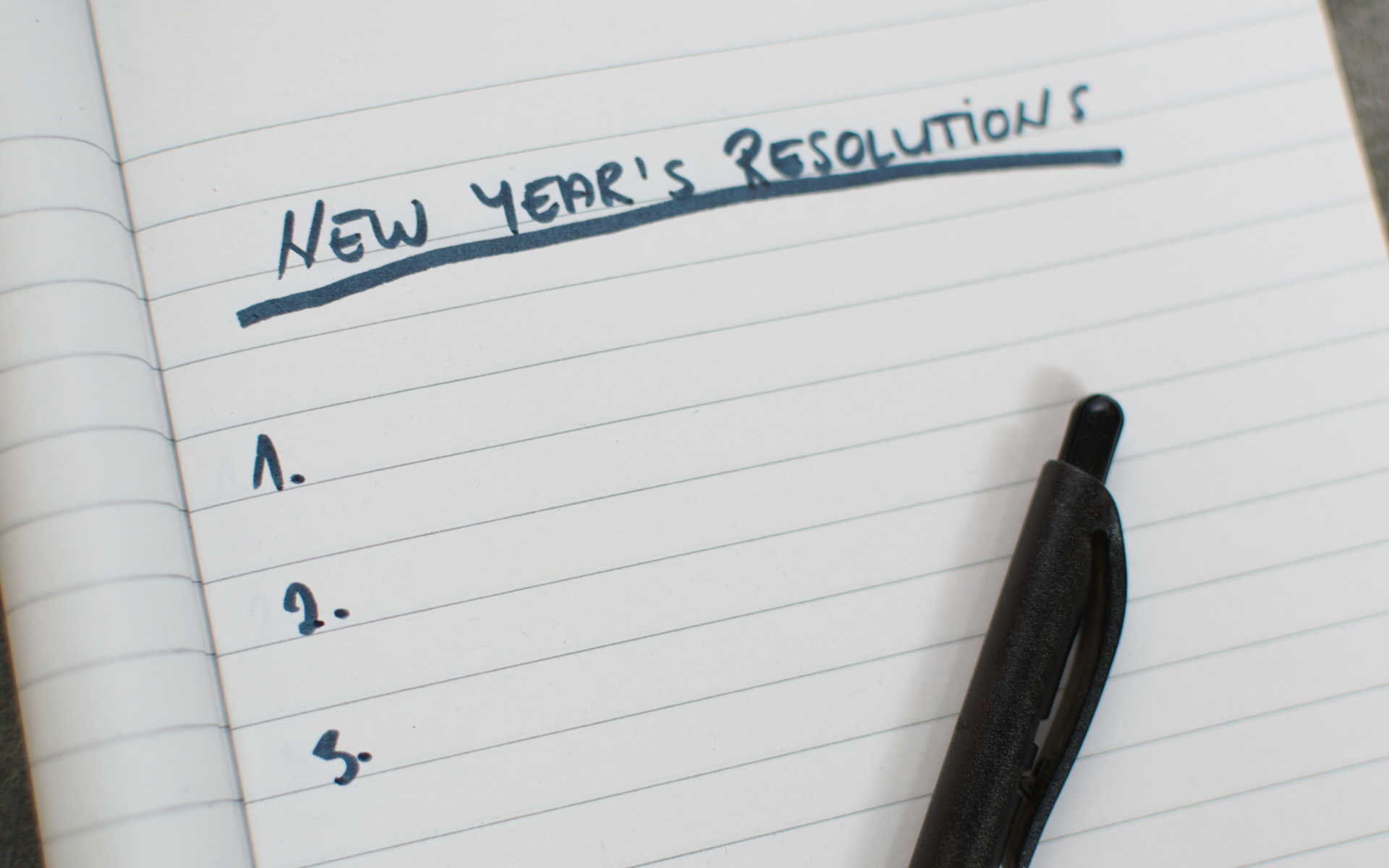 nyr blog Piece of paper that says New Year's Resolutions at the top with a blank list underneath