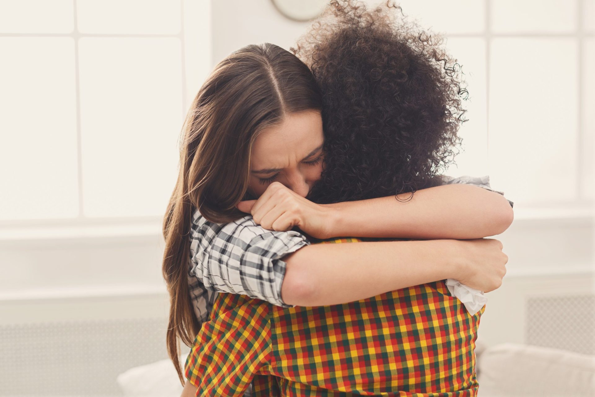 Woman hugging her depressed friend at home two women hugging