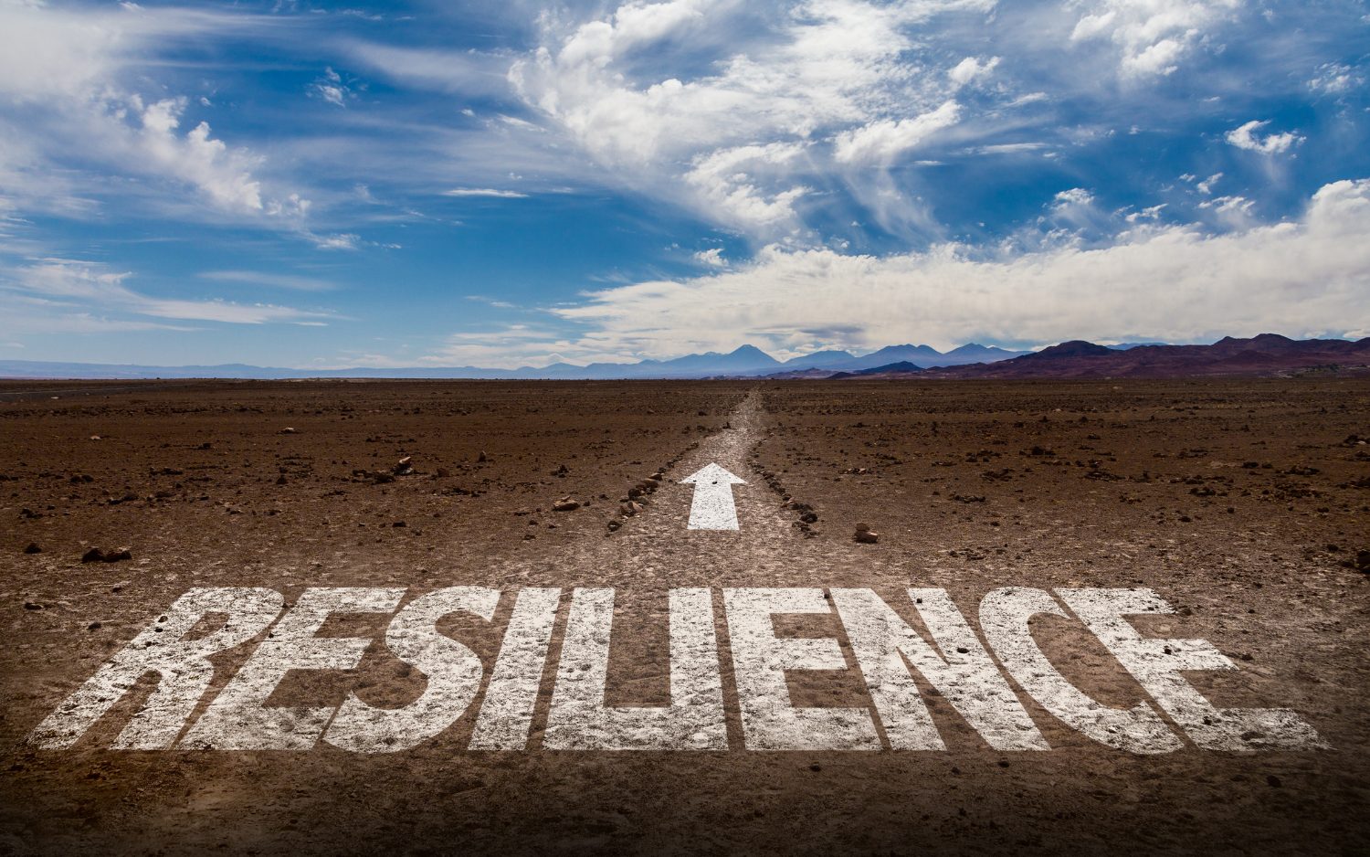 resilience the word resilience superimposed on the ground with and arrow pointing on the path ahead