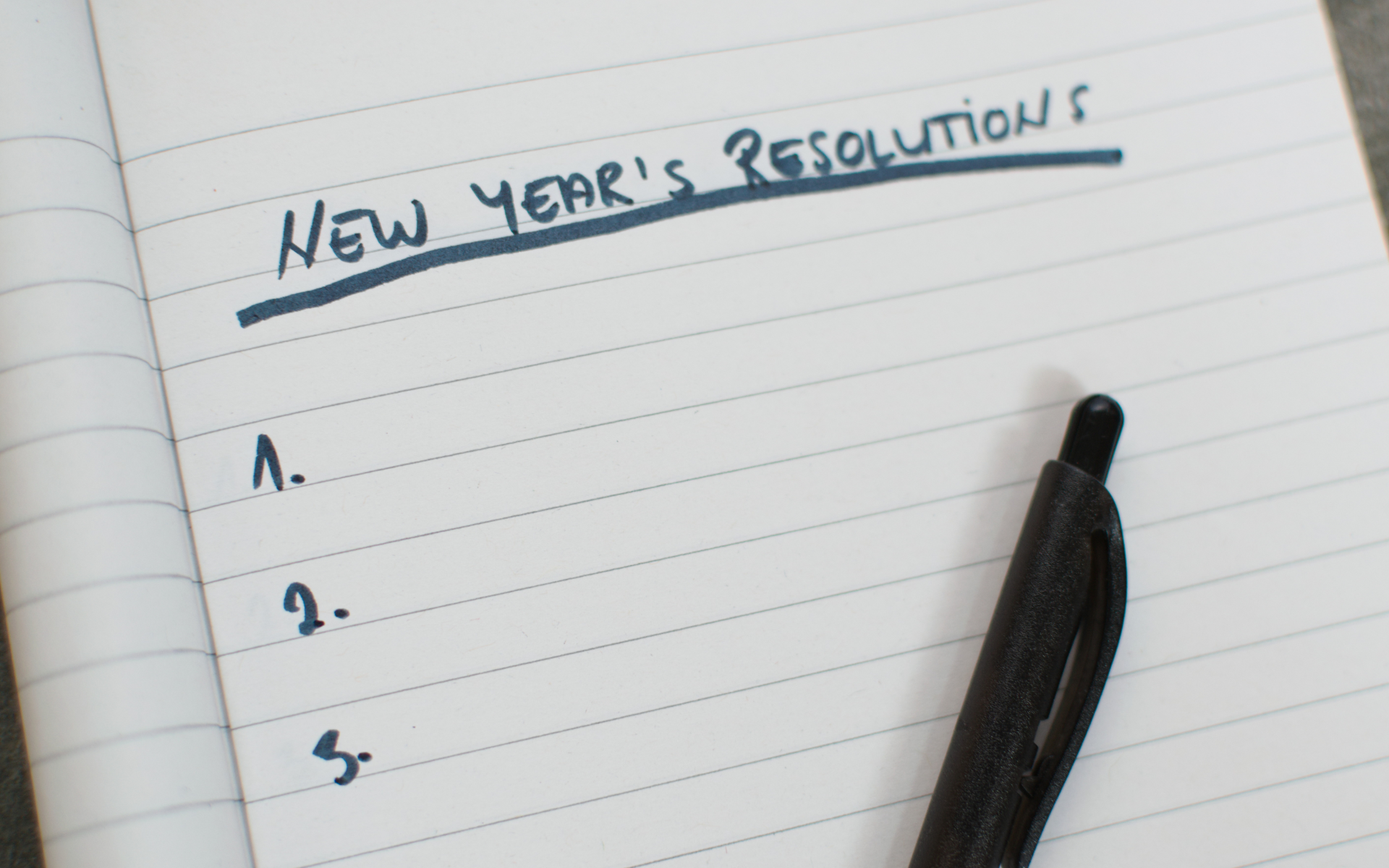 Piece of paper that says New Year's Resolutions at the top with a blank list underneath