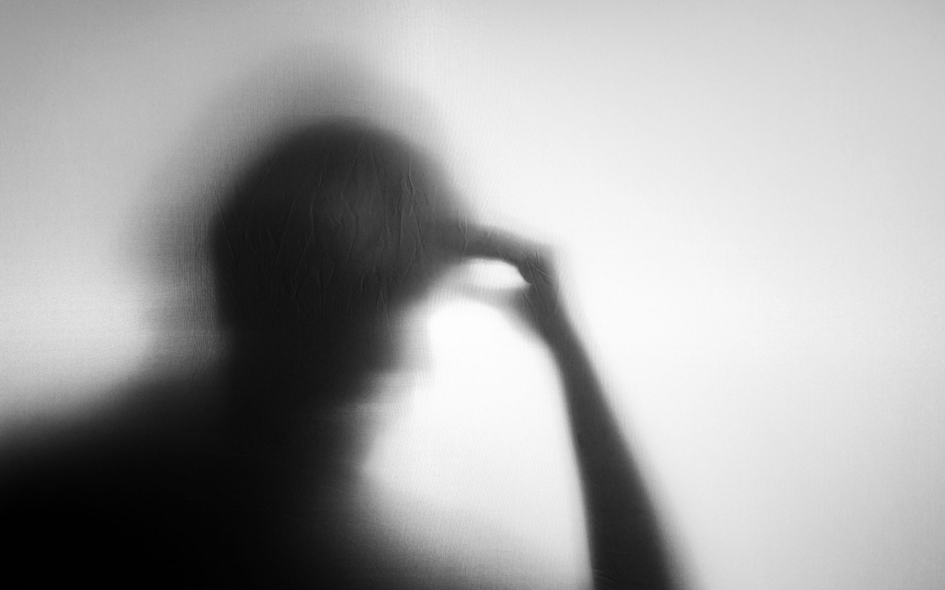 shadow of person resting their head in their hands