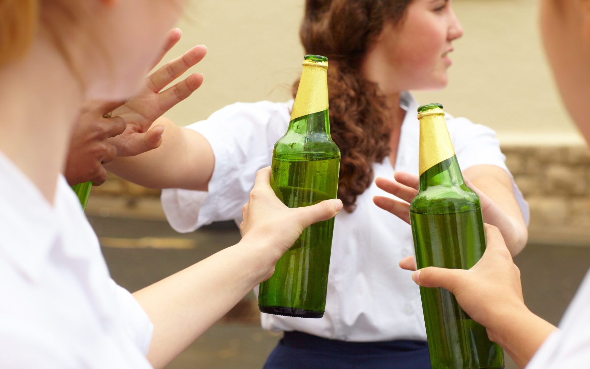 Teen being pressured into drinking by peers