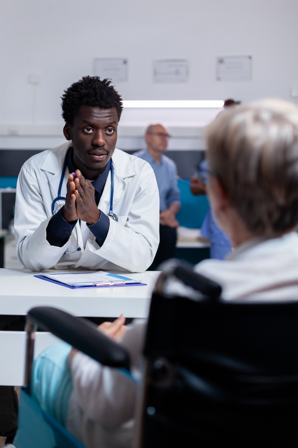 Young doctor talking to patient in office.