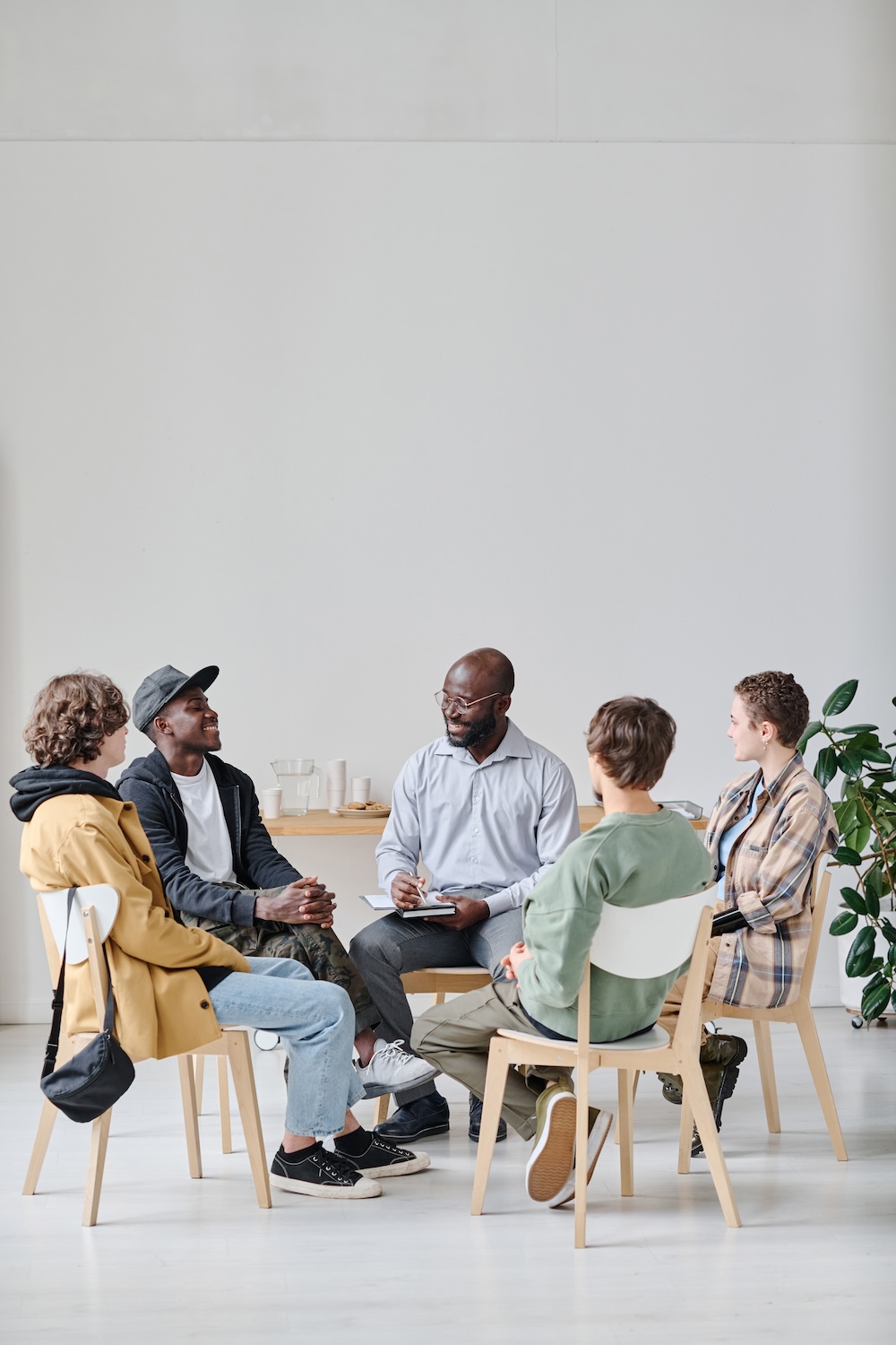 Group of clients sitting on chairs with clinician 