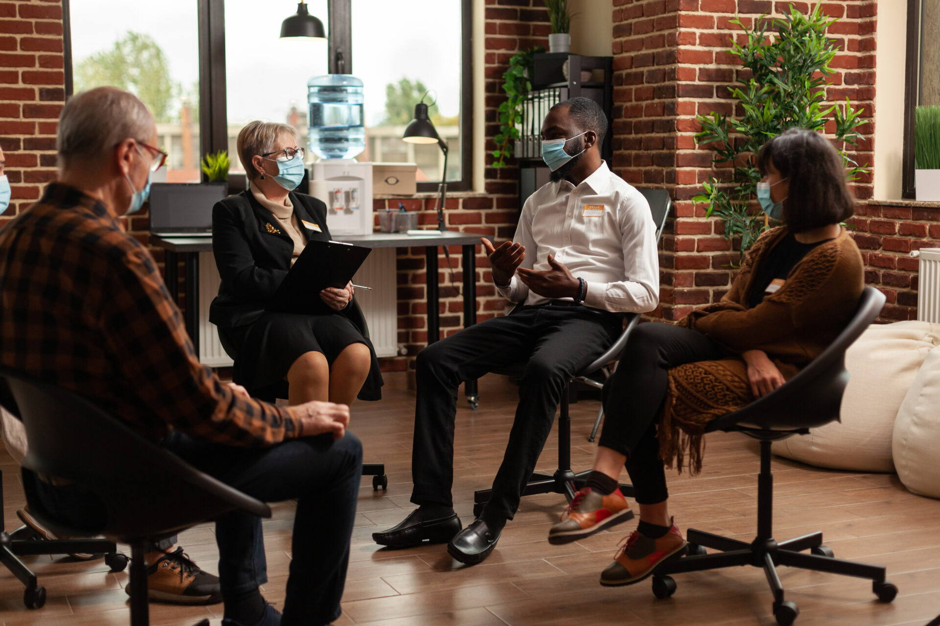 Multi ethnic people discussing about addiction at support group therapy